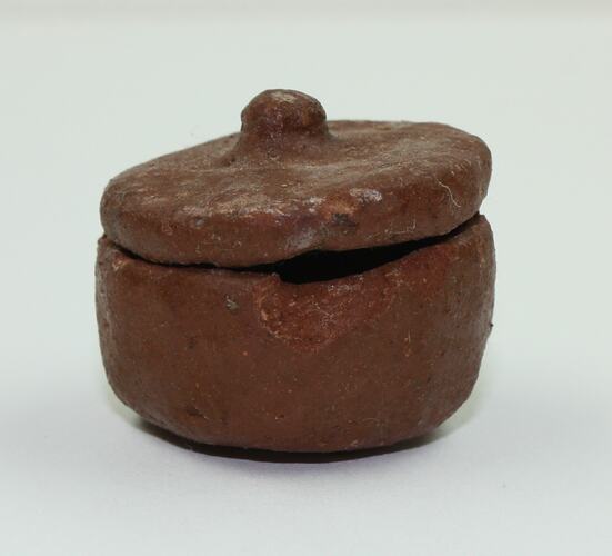 Clay toy pot viewed from side.