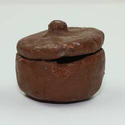 Clay toy pot viewed from side.