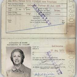 Open passport with two white pages with printed pattern. Printed and handwritten text. Photo of female.