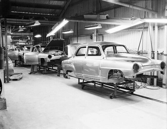 Monochrome photograph of a vehicle manufacturing plant.