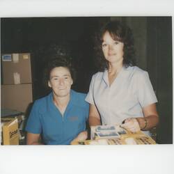 Two women in warehouse of photographic products.