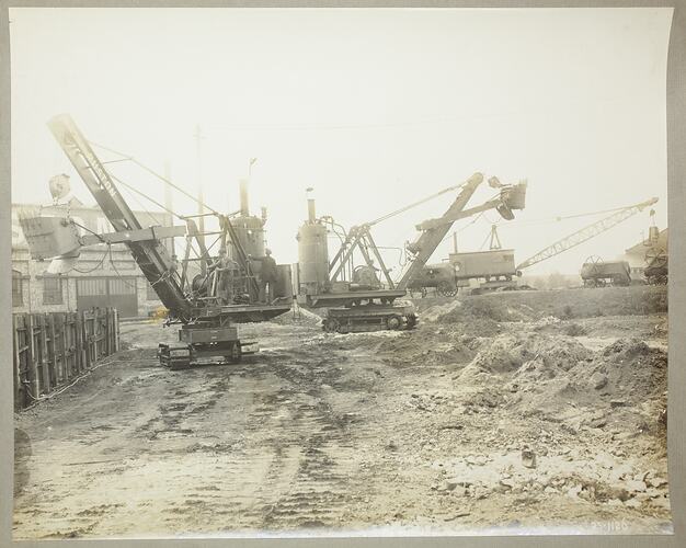 Monochrome photograph of two shovel excavators.