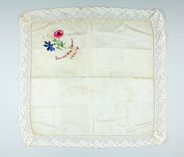 Square white cloth with embroidered flowers at top left