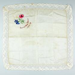 Square white cloth with embroidered flowers at top left
