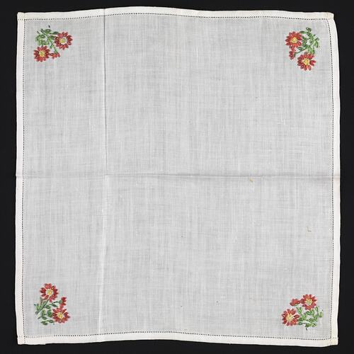 Unfolded white Handkerchief with embroidered dark pink flowers.