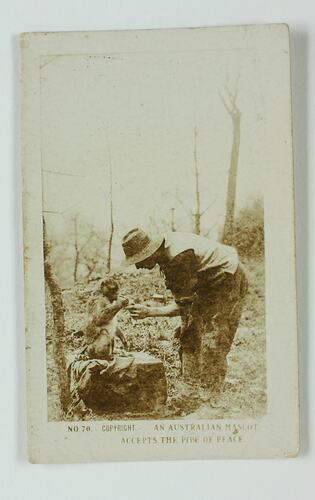 Servicemen bending down and handing pipe to monkey.