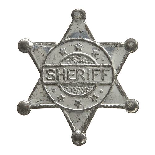 Toy star-shaped silver metal sheriff badge.
