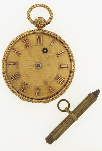 Gold pocket watch, open. Decorative cap, ring & bezel. Gold matt dial has raised gold roman numerals.