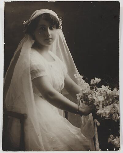 Bride holding posy, seated.