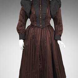 Burgundy and black satin striped dress. Fitted bodice, long sleeves, black buttons and billowed shoulders.