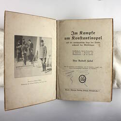 Inside pages of book showing photo of men and title page.