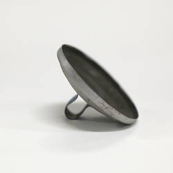 Side view of tiny aluminium pot lid showing inside and handle.