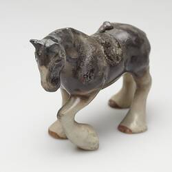 Fire affected brown and cream ceramic horse figurine.