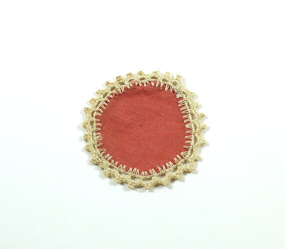 Tiny orange placemat, lace edge.