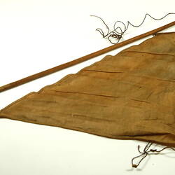 Brown triangular cloth with wooden rod.