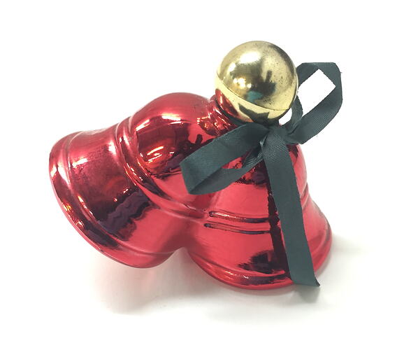 Red perfume bottle shaped like two christmas bells. Gold bauble lid with green fabric bow.
