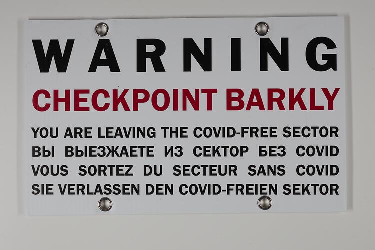 White sign with black and red printed text.