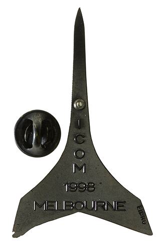 Back of arrow shaped medal, fine point at tip. Has maker's details and stick pin attachment.