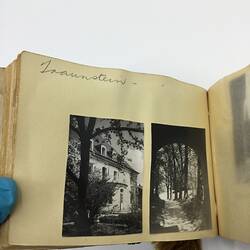 Two black and white photos glued on page of album with handwritten annotation in pencil above.