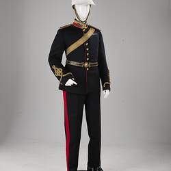 Navy officer's uniform with gold at cuff, epaulettes, belt. Brass buttons. Red/gold collar. White helmet.