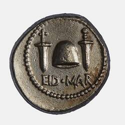 Round coin with domed hat, dagger eitherside.