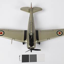 Top view of silver model aeroplane. Red, white, blue roundels on wings. Black propeller.