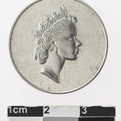 Round silver coloured medal with profile of a crowned woman.