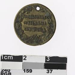 Round medal with text and wreath surrounding.