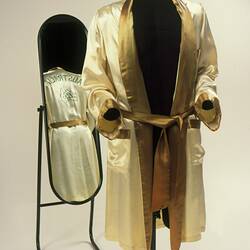 Satin gold boxing gown, front, with reflection of back in a mirror.