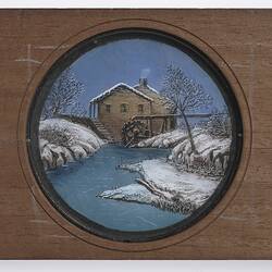 Wooden slide showing winter scene at water wheel.