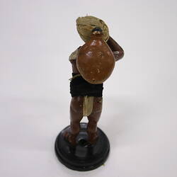 Reverse side of a clay figurine carrying a heavy load.