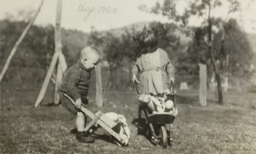 Children playing with toy wheelbarrows.