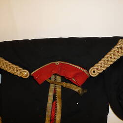 Black military uniform jacket with gold embroidery, view of collar and shoulders.