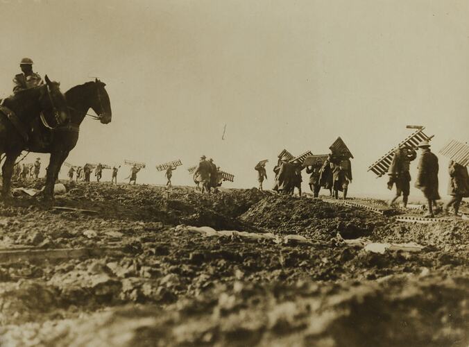 Soldiers carrying segments of duckboard.