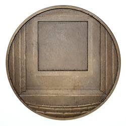 Round bronze medal with blank squares.