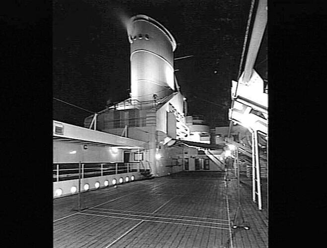 Ship funnel and deck, night view.