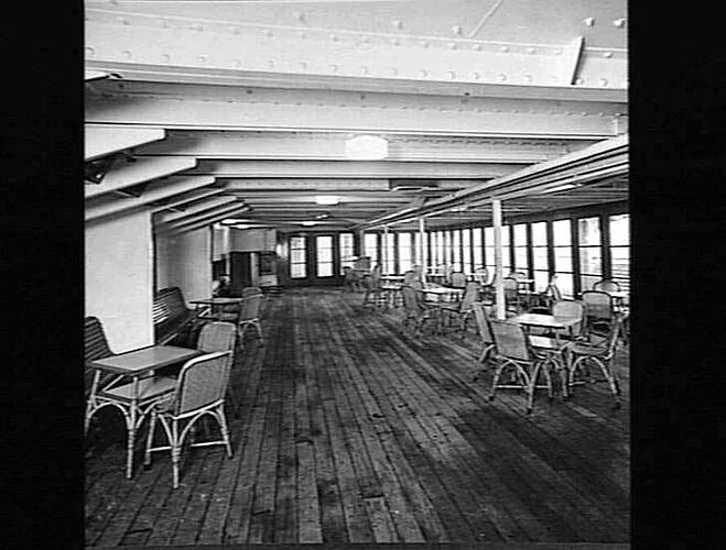 Ship interior. Deck dancefloor with cane tables and chairs.