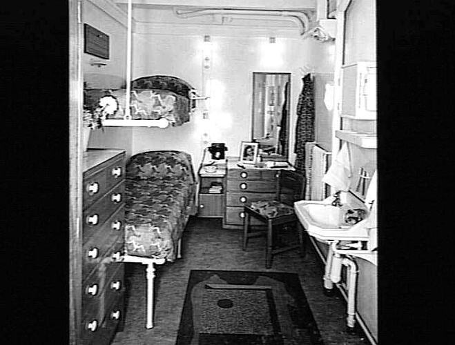 Ship interior. Beds on left walls. Chest of drawers at right.