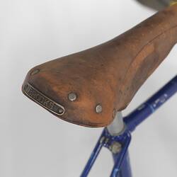 Detail of blue metal bicycle leather seat.