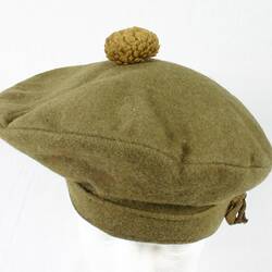 Green felt uniform beret with pompom on top.