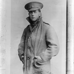 Studio portrait of man in coat and military cap.