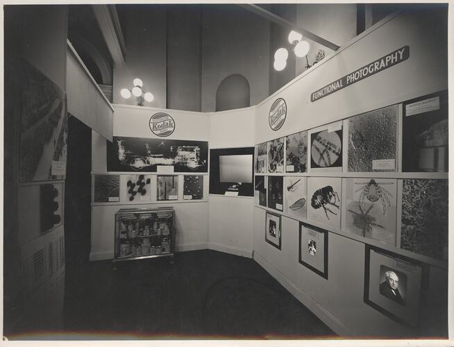 Exhibition booth with photographs and projection screen.