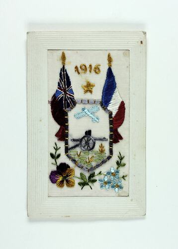 Embroidered postcard with flags, flowers and gun.