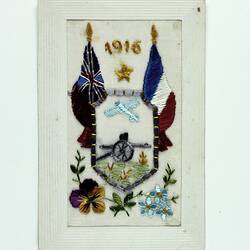 Embroidered postcard with flags, flowers and gun.