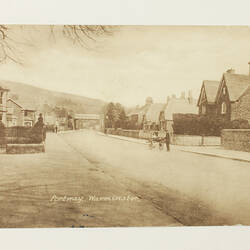 Front of postcard with photo of village.