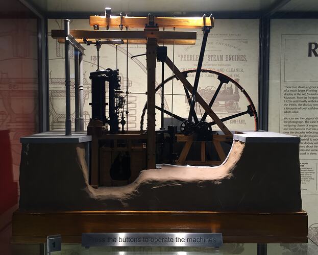 Model steam engine in display case.