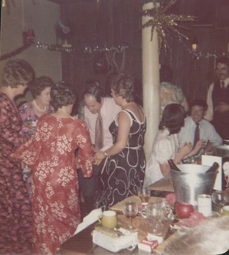People dancing next to a table.