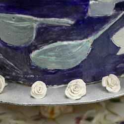 Side detail of lower tier of ceramic wedding cake.