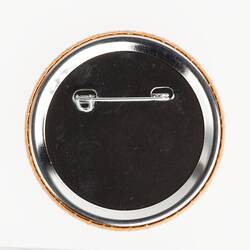 Back of round metal badge. Horizontal pin.