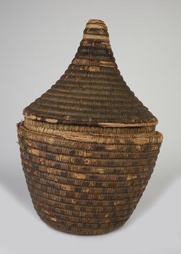 Woven fibre round basket with conical lid.